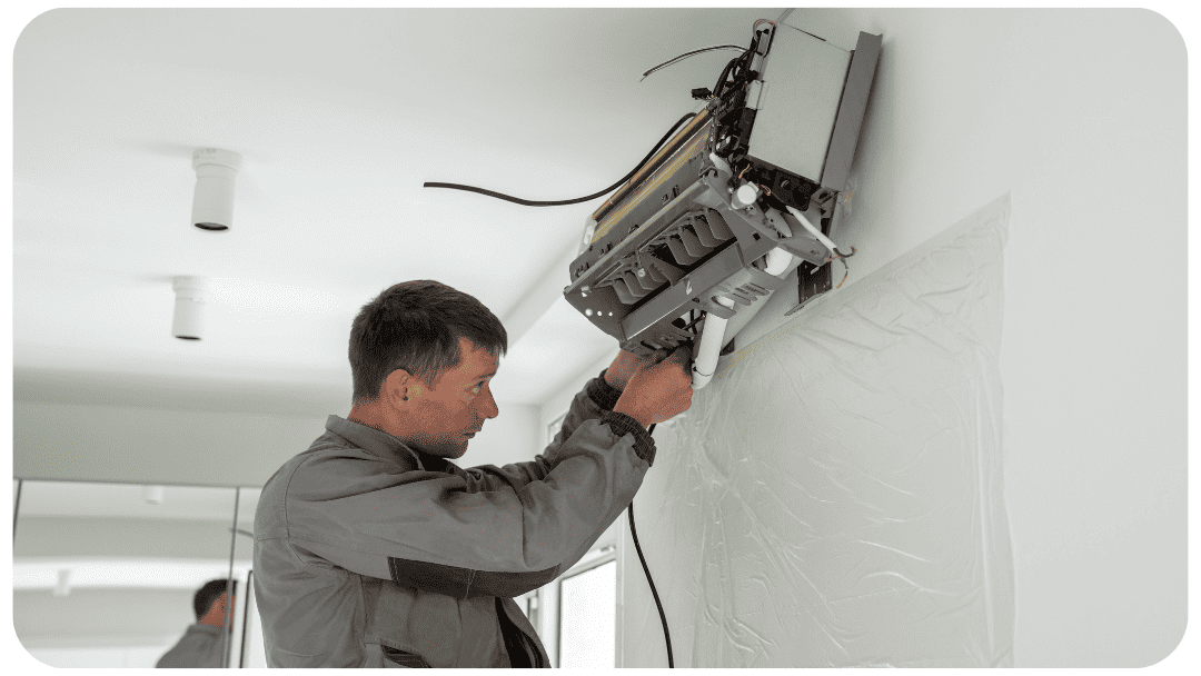 A professional technician working diligently on the installation of a modern wall ductless mini split unit. Mini Split Troubleshooting: Do’s And Don’ts Doing It Yourself
